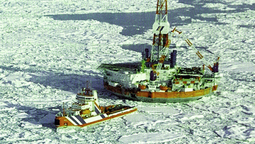 A small ship tows a floating offshore drilling rig through the ice