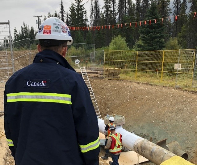 Figure 4 – A CER Inspector observes work on a section of pipe at a Trans Mountain site, near Jasper, Alberta.