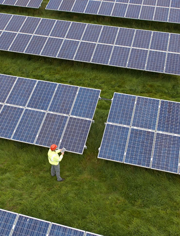 An aerial view of an Engineer checking a solar farm site