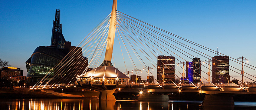 The Canadian Museum for Human Rights and Esplanade Riel bridge at dusk in Winnipeg, Manitoba.