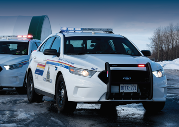 Front view of two RCMP cruiser in rural environment