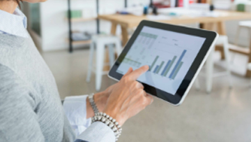 A close up of someone who’s reviewing graphs on a tablet