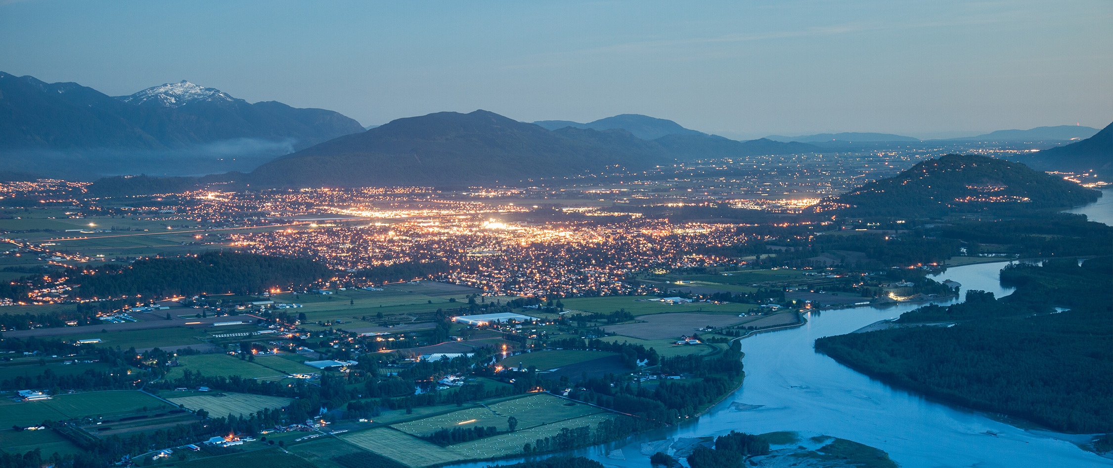 Ville entourée de montagnes au crépuscule