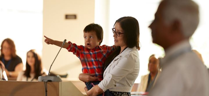 Woman and child speaking at a hearing