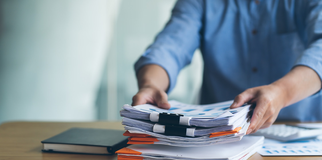 Person stacking papers on a desk