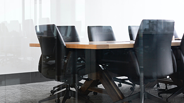 An image of boardroom table and chairs