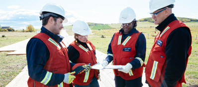 Four CER inspectors looking at documents in the field