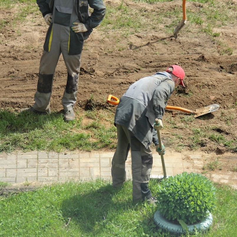 Figure 3 – Des travailleurs réparent un trottoir et l'aménagement paysager environnant.
