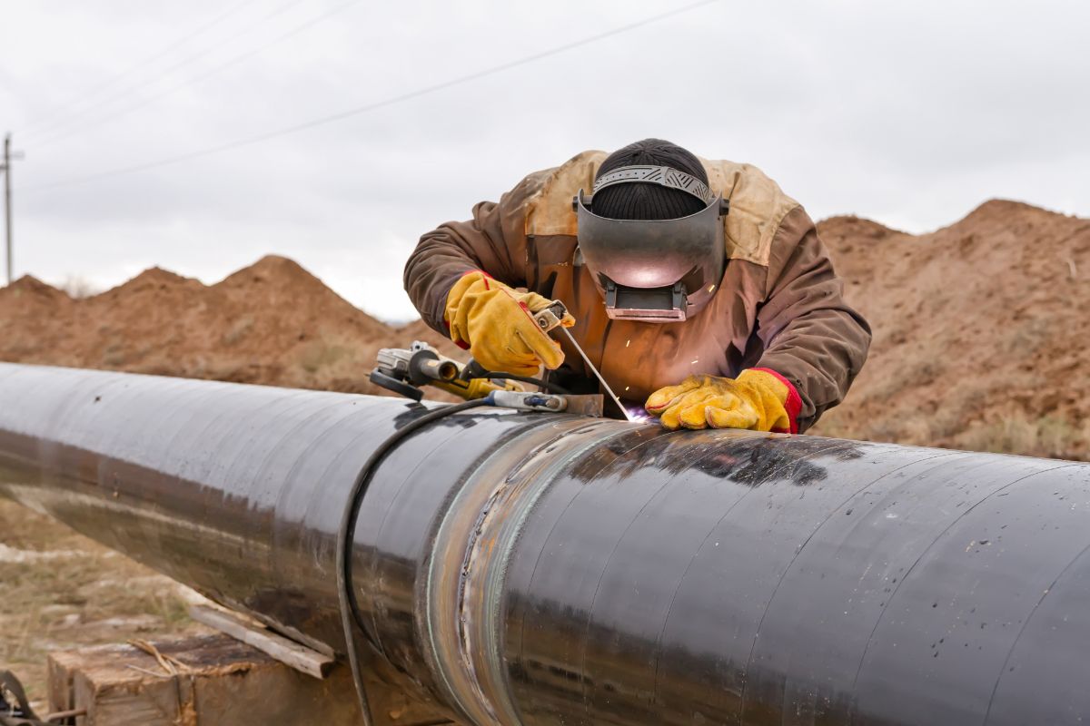 Travailleur soudant un pipeline.