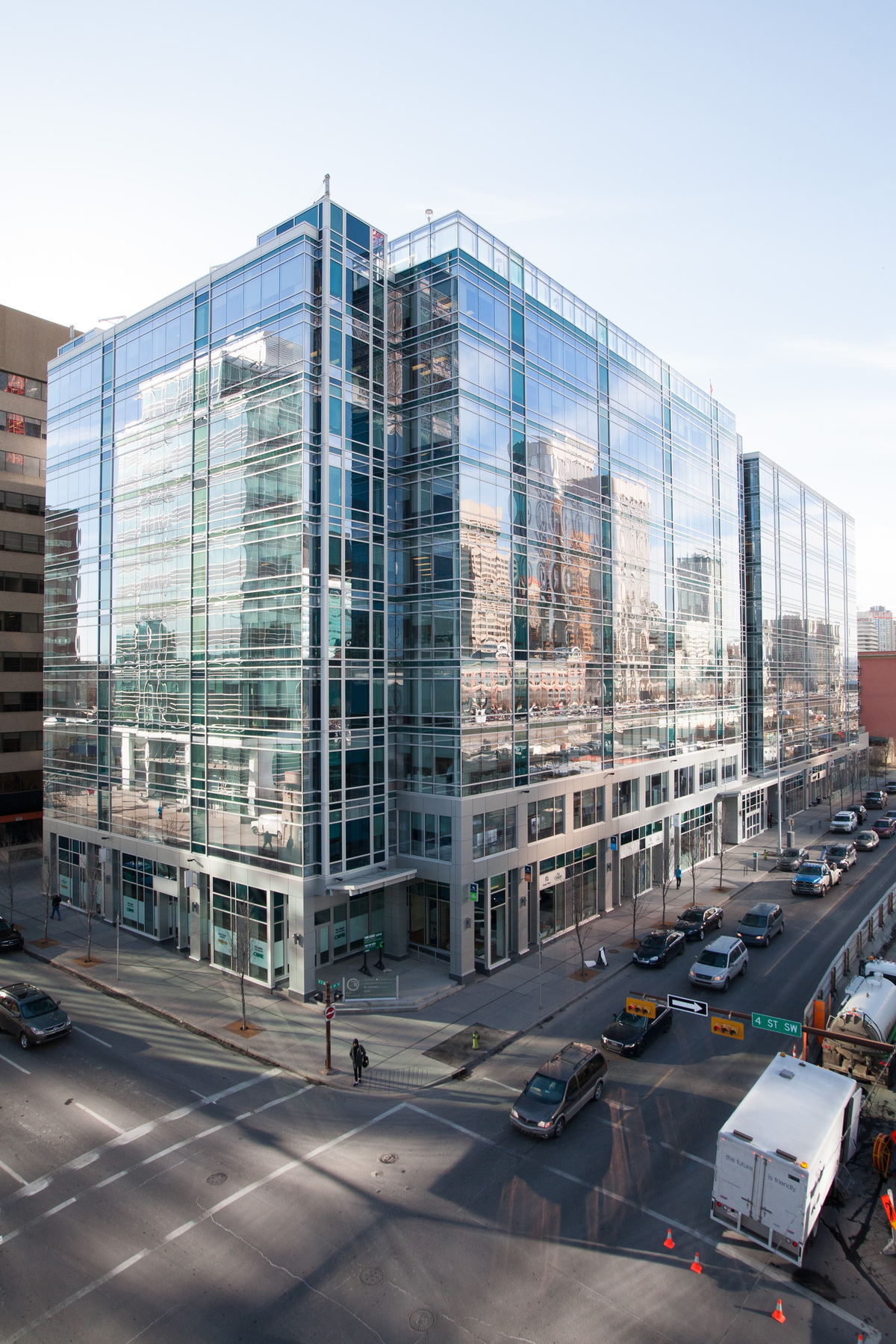 Le Centre10, bâtiment où se trouvent les bureaux de la Régie de l’énergie du Canada, reflète la ligne d'horizon du centre-ville de Calgary dans ses vitres et la rue en contrebas.