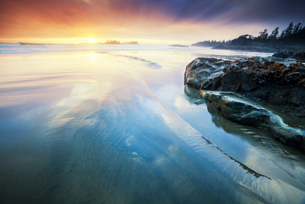 View along the B.C. coast at sunset, the sky and clouds are multicoloured