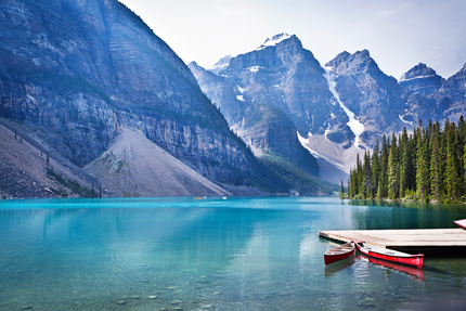 Two red canoes float at the dock of Moraine Lake