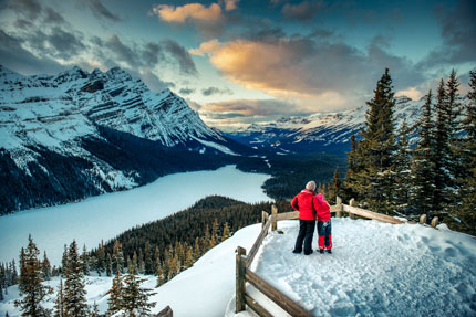 Une mère et sa fille admirent le lac Peyto sous la glace d’hiver