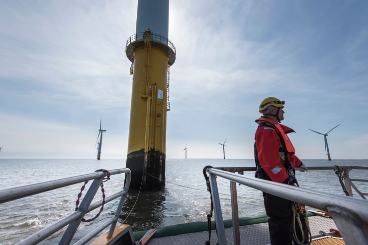Engineer prepares to climb a wind turbine at an offshore windfarm