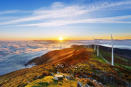 Des éoliennes côtières au coucher de soleil.