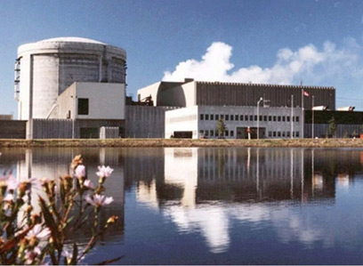 Centrale nucléaire de Point Lepreau sous un ciel radieux avec chardons à l’avant-plan