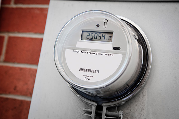 A residential smart meter attached to a brick wall.