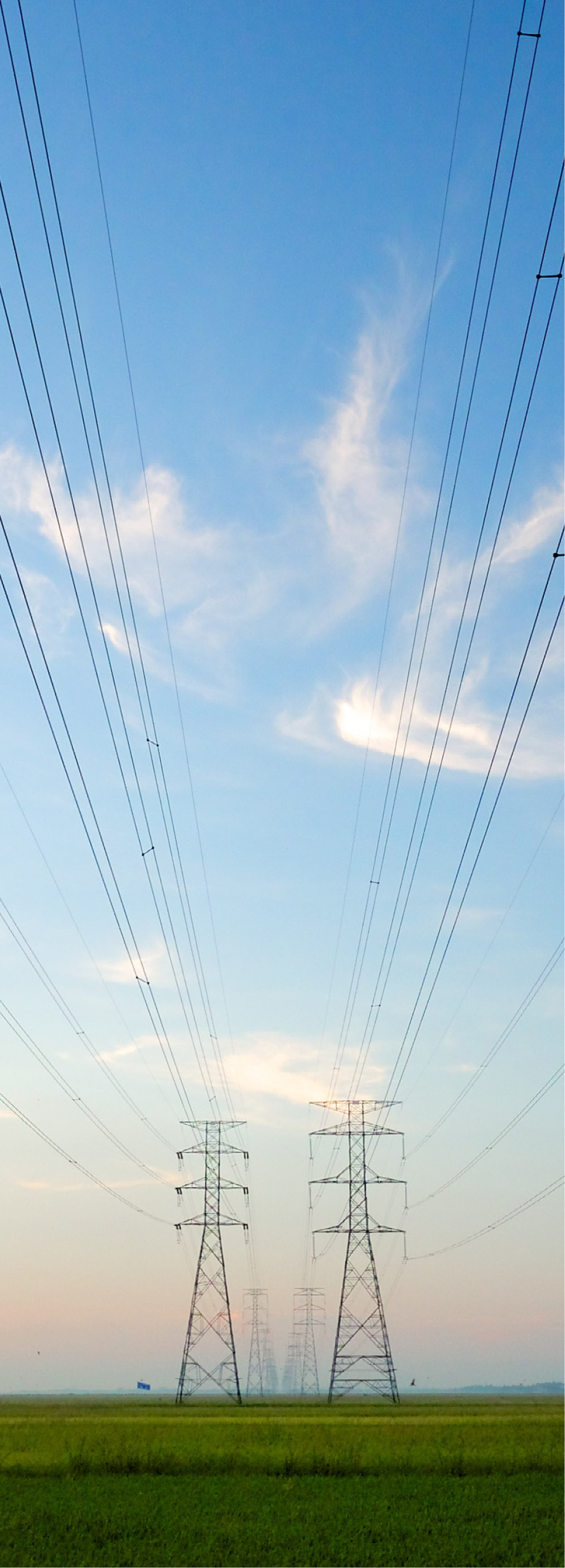 Power transmission lines fade out into the distance on a semi cloudy day.