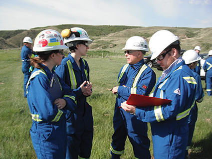 Sur une colline herbeuse, des inspecteurs de la Régie mènent un exercice de groupe.