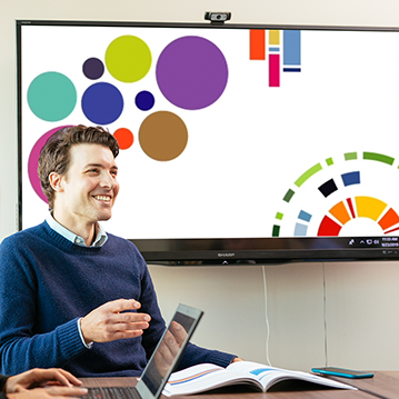 CER employee at meeting with screen behind showing Data Visualizing graphic