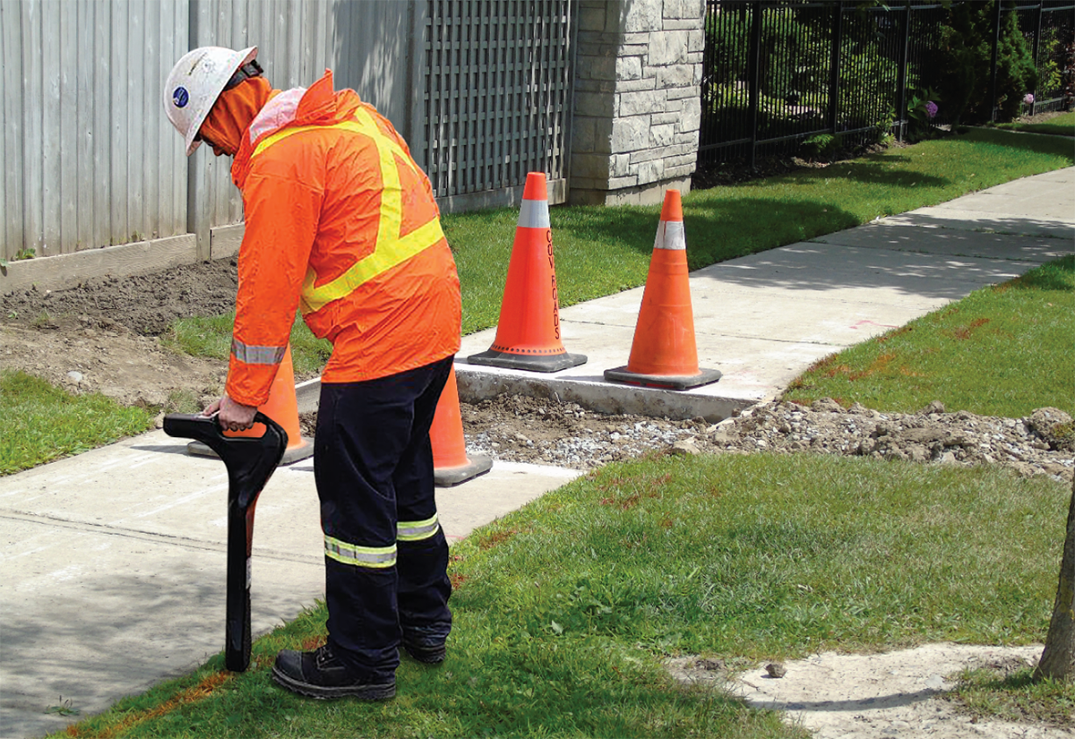 Localisateur de pipeline près d’un trottoir dans un secteur résidentiel