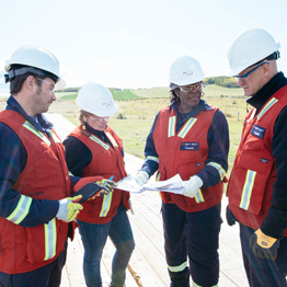 Quatre inspecteurs de la Régie ayant différentes spécialités techniques sont réunis pour discuter de ce qu’ils ont vu pendant l’inspection d’un chantier de construction.